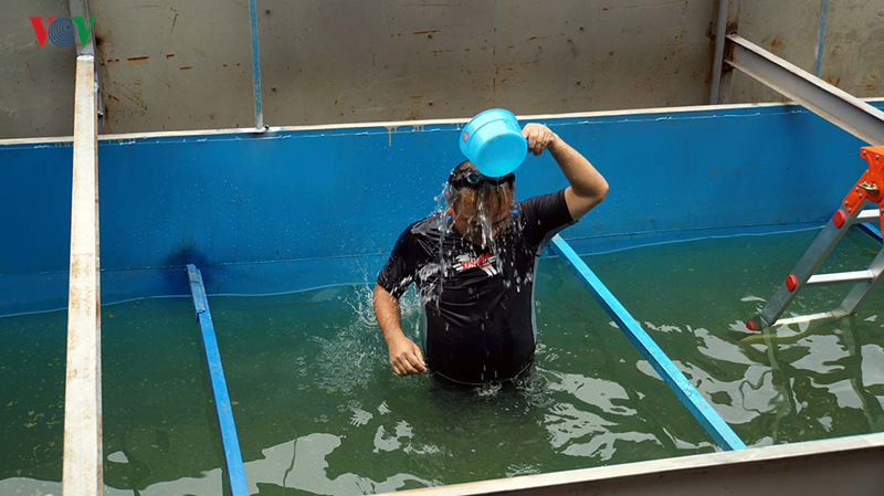 TS.Kubo Jun bơi và dội nước lên mặt trong khu vực trình diễn xử lý nước sông Tô Lịch.